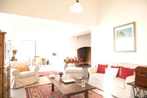 een woonkamer met witte meubels en een tafel bij Chic Villa with Private Pool near Évora in São Miguel de Machede