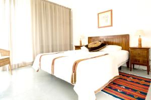 een witte slaapkamer met een bed en een tapijt bij Chic Villa with Private Pool near Évora in São Miguel de Machede +19 foto's