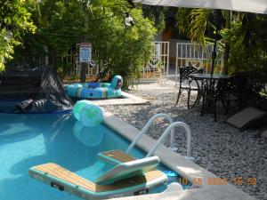 uma piscina com duas cadeiras e uma mesa em Gustave Vacation House em Port-au-Prince