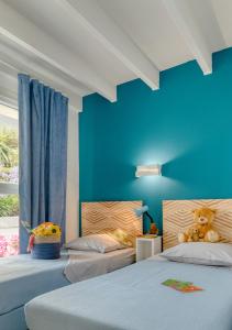 um quarto com 2 camas e uma parede azul em KER-AR-MOR Village Vacances em Le Pouldu