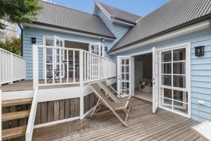una terraza con una mecedora en una casa azul en Mornington Peninsula Hamptons Inspired Gem - New listing, en Rye