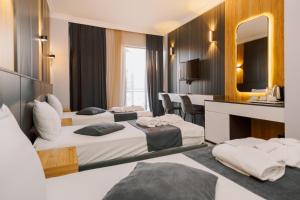 pokój hotelowy z 3 łóżkami i lustrem w obiekcie Bel Mare Boutique Hotel w mieście Batumi
