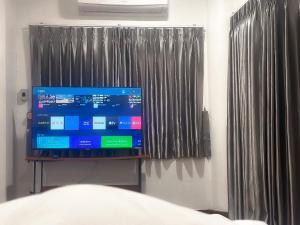 een televisie op een stand in een slaapkamer bij Thonglor 25 Classic Home 5BR/7Beds/14PPL in Ban Na Song