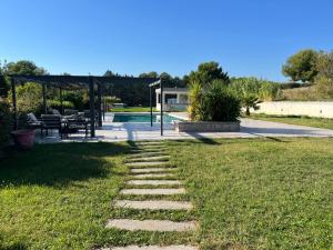 einen Garten mit einem Steinweg, der zu einem Pool führt in der Unterkunft Lot de deux villas a louer dans un cadre idyllique a Gemenos in Gémenos