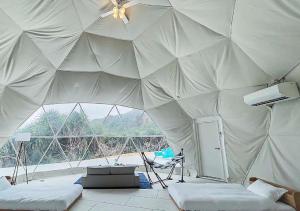 a tent with two beds in a room with a window at glampark resort Akuna beach in Henza