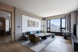 a living room with a couch and a table at Wuhan Marriott Hotel Optics Valley in Wuhan