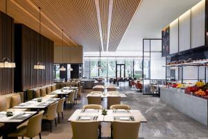 uma sala de jantar com mesas e cadeiras num restaurante em Wuhan Marriott Hotel Optics Valley em Wuhan