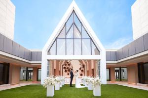 Una novia y un novio parados frente a una capilla en Wuhan Marriott Hotel Optics Valley en Wuhan