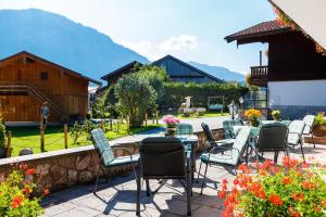 a patio with a table and chairs and mountains at Gästehaus beim Schneidersepp in Ruhpolding