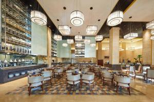 福州天元国际威斯汀酒店 في فوتشو: غرفة طعام مع طاولات وكراسي في مطعم