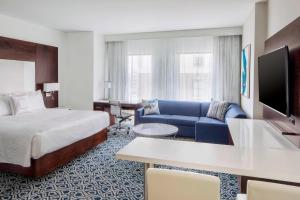 a hotel room with a bed and a blue couch at Residence Inn by Marriott Stamford Downtown in Stamford