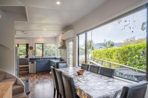 eine Küche und ein Esszimmer mit einem Tisch und Stühlen in der Unterkunft Bay View - Wainui Holiday Home in Akaroa