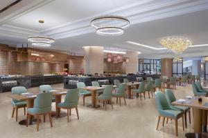 a restaurant with tables and chairs and a buffet at Sheraton Shaoxing Shangyu in Shaoxing