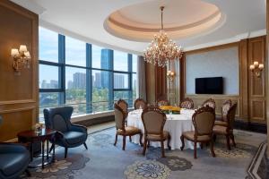a dining room with a table and chairs and a large window at Sheraton Shaoxing Shangyu in Shaoxing