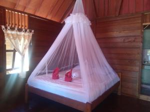 1 cama con almohadas rojas en una habitación de madera en Famangkor Homestay, en Yennanas Besir