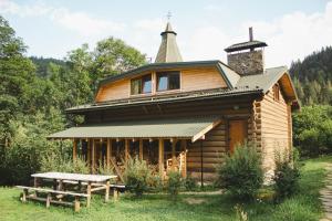 eine Holzhütte mit einem Picknicktisch davor in der Unterkunft Camp Bilyi Slon in Dsembronja