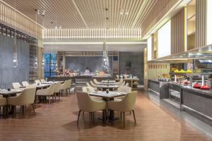 a restaurant with tables and chairs and a buffet at Wuxi Marriott Hotel Lihu Lake in Wuxi