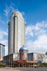 un grand bâtiment avec une grande tour en face dans l'établissement Sheraton Guiyang Hotel, à Guiyang