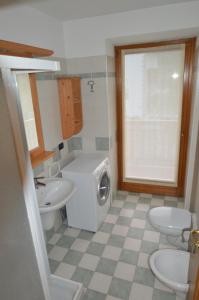 une salle de bain avec une machine à laver et un lavabo dans l'établissement Appartamenti Centrale, à Andalo