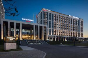 a large building in front of a building at Courtyard by Marriott Zhengzhou Airport in Zhengzhou