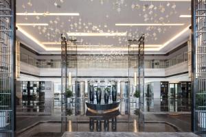 a lobby of a building with a chandelier at Courtyard by Marriott Zhengzhou Airport in Zhengzhou