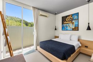 - une chambre avec un lit et une grande fenêtre dans l'établissement Villa Sunpao, à Layan Beach