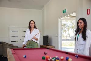 two women playing pool in a room at RAC Cervantes Holiday Park in Cervantes