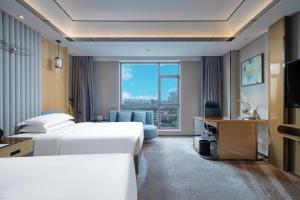 um quarto de hotel com duas camas e uma secretária e uma janela em Courtyard by Marriott Nanchang em Nanchang