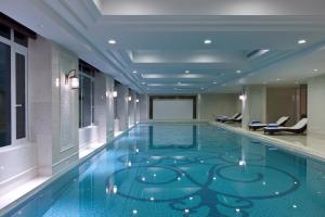 a swimming pool with a blue floor in a building at Sheraton Changzhou Wujin Hotel in Changzhou