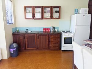 uma cozinha com um lavatório e um frigorífico branco em Bright & breezy chalet close to town & beach em Dunsborough