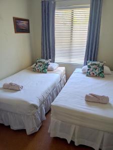 2 camas individuales en una habitación con ventana en Bright & breezy chalet close to town & beach, en Dunsborough