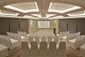 a conference room with white chairs and a projection screen at Courtyard by Marriott Hangzhou Qianjiang in Hangzhou