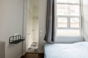1 dormitorio con cama y ventana en Maison standing 9 chambres 5SB avec extérieur, en Roubaix
