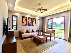 MonMonBoutique Hotel في Thakho: غرفة معيشة مع أريكة وطاولة
