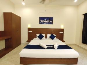 PV Resort - Auro Beach في أورفيلا: غرفة نوم بسرير كبير ومخدات زرقاء وبيضاء