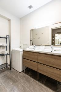 łazienka z 2 umywalkami i dużym lustrem w obiekcie La bulle de Vichy Maison 4 pers tout confort w mieście Vichy