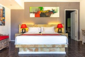 a bedroom with a large bed with two lamps at Aleesha Villas and Suites in Sanur