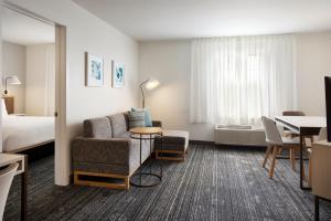 a hotel room with a couch and a bed at TownePlace Suites Dulles Airport in Sterling