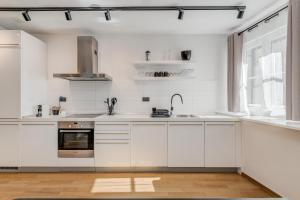 een witte keuken met witte kasten en een raam bij 385 Luxury Suites in Split