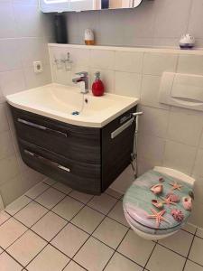 baño con lavabo y aseo con taburete en Apartment in Gilching en Gilching