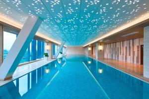 una gran piscina con techo azul en Hangzhou Marriott Hotel Qianjiang en Hangzhou