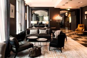 a lobby with a couch and chairs and a table at Hotel Telegraaf, Autograph Collection in Tallinn