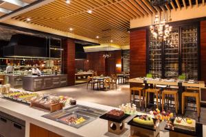 um restaurante com um buffet e uma sala de jantar em Shunde Marriott Hotel em Shunde