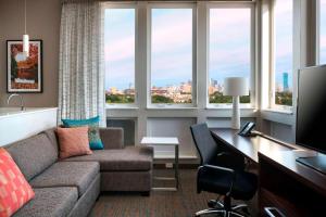 a living room with a couch and a desk and windows at Residence Inn by Marriott Boston Watertown in Watertown
