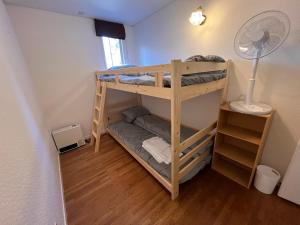 two bunk beds in a room with a fan at TaoTechHOUSE in Hakuba