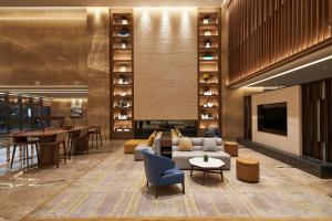 a lobby with a couch and a tv and tables at Four Points by Sheraton Jiaxing in Jiaxing
