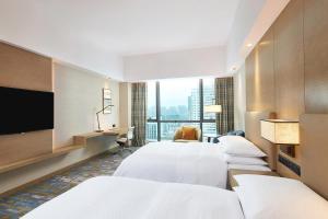 a hotel room with four beds and a flat screen tv at Four Points by Sheraton Jiaxing in Jiaxing