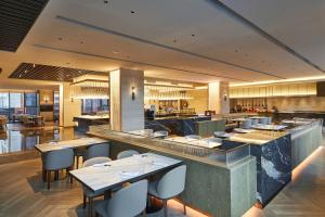 a restaurant with tables and chairs in a room at Four Points by Sheraton Jiaxing in Jiaxing