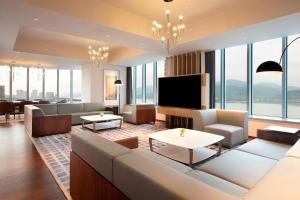 a living room with a couch and a flat screen tv at Le Meridien Hangzhou, Binjiang in Hangzhou