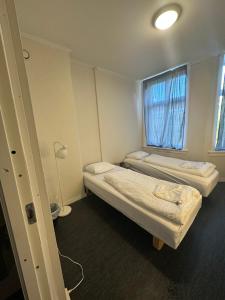 2 Betten in einem kleinen Zimmer mit Fenster in der Unterkunft Center apartments in Oslo